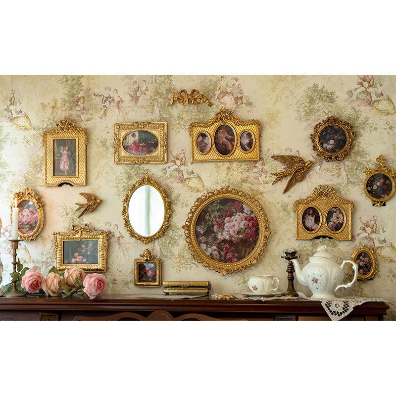 Ornate gold picture frames with mirror accent arranged on wall for vintage European home decor